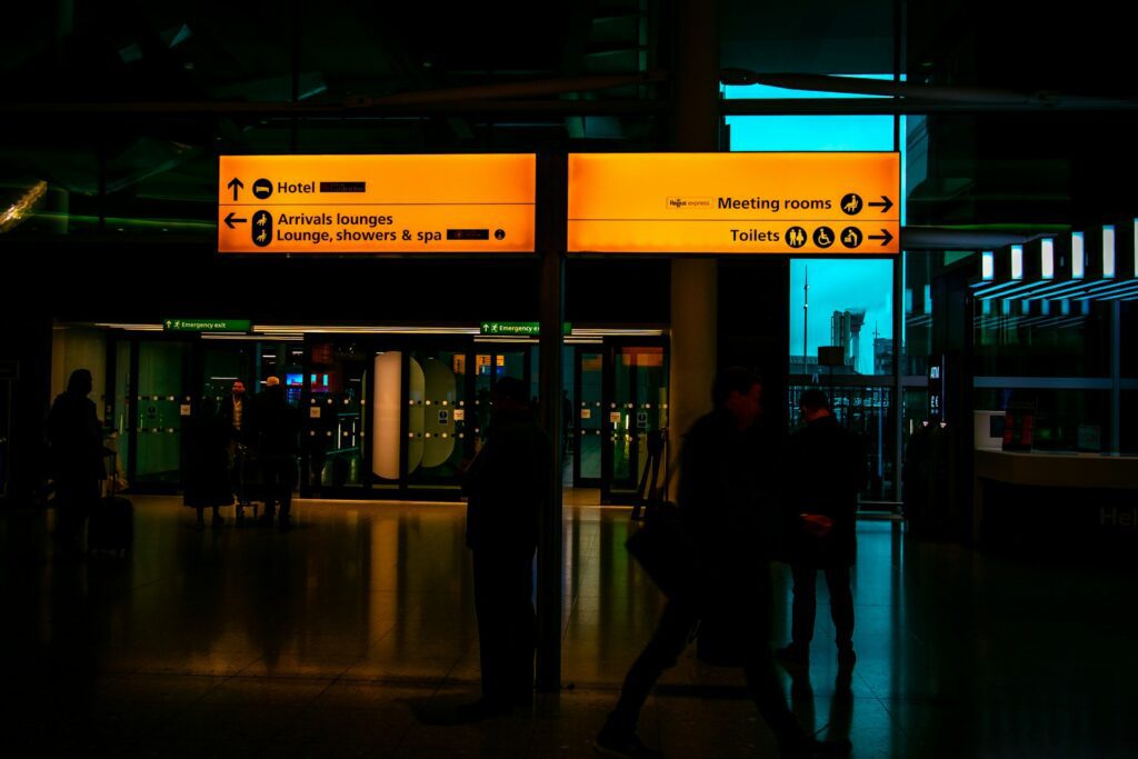 A group of people walking through a terminal at night.