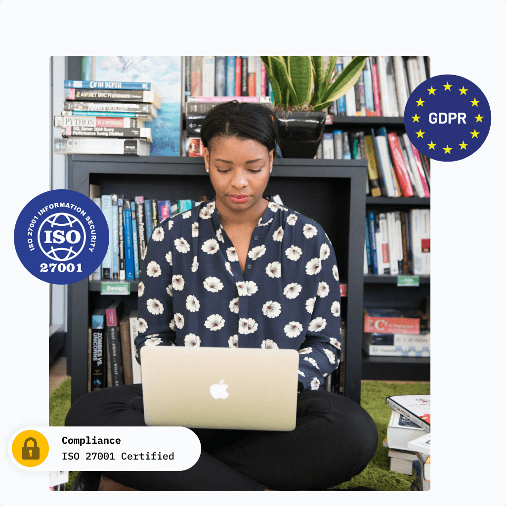 Woman sitting with laptop in her lap in front of a bookshelf.